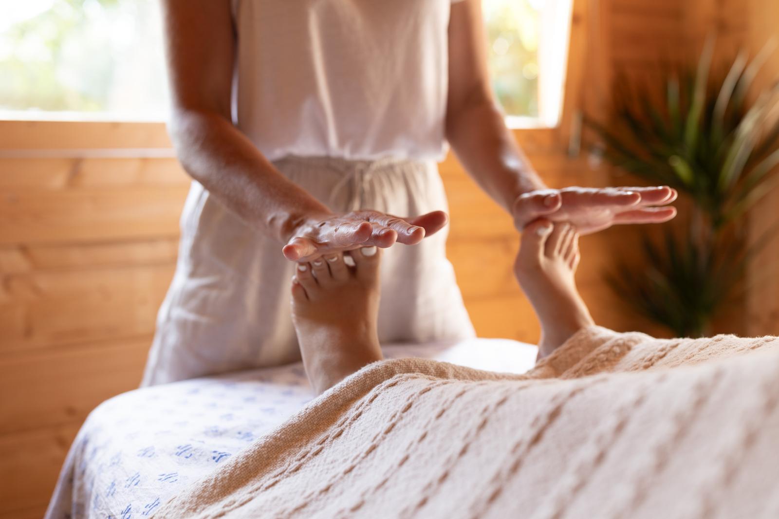 Therapist's hands gently massaging a client's feet